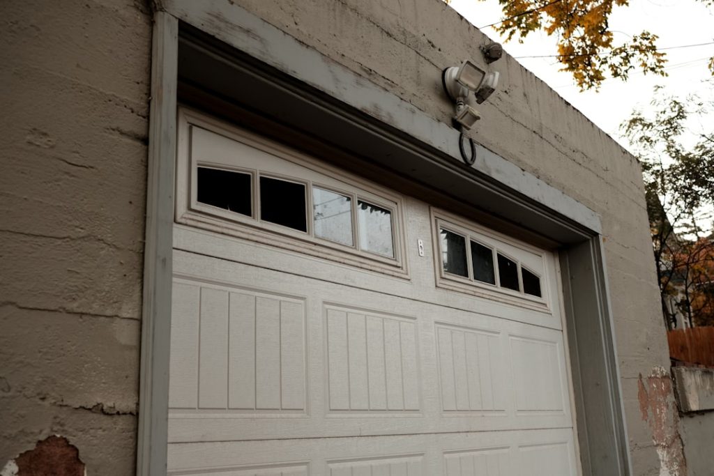 a-white-garage-door-on-a-brick-building-gc2zel5dihu